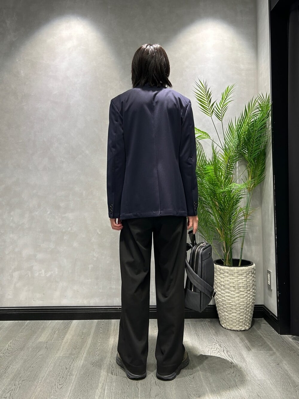 グレー系のニット/セーター、ブルー系のテーラードジャケット、グレー系のショルダーバッグを着用したメンズの秋コーディネートの3枚目の写真