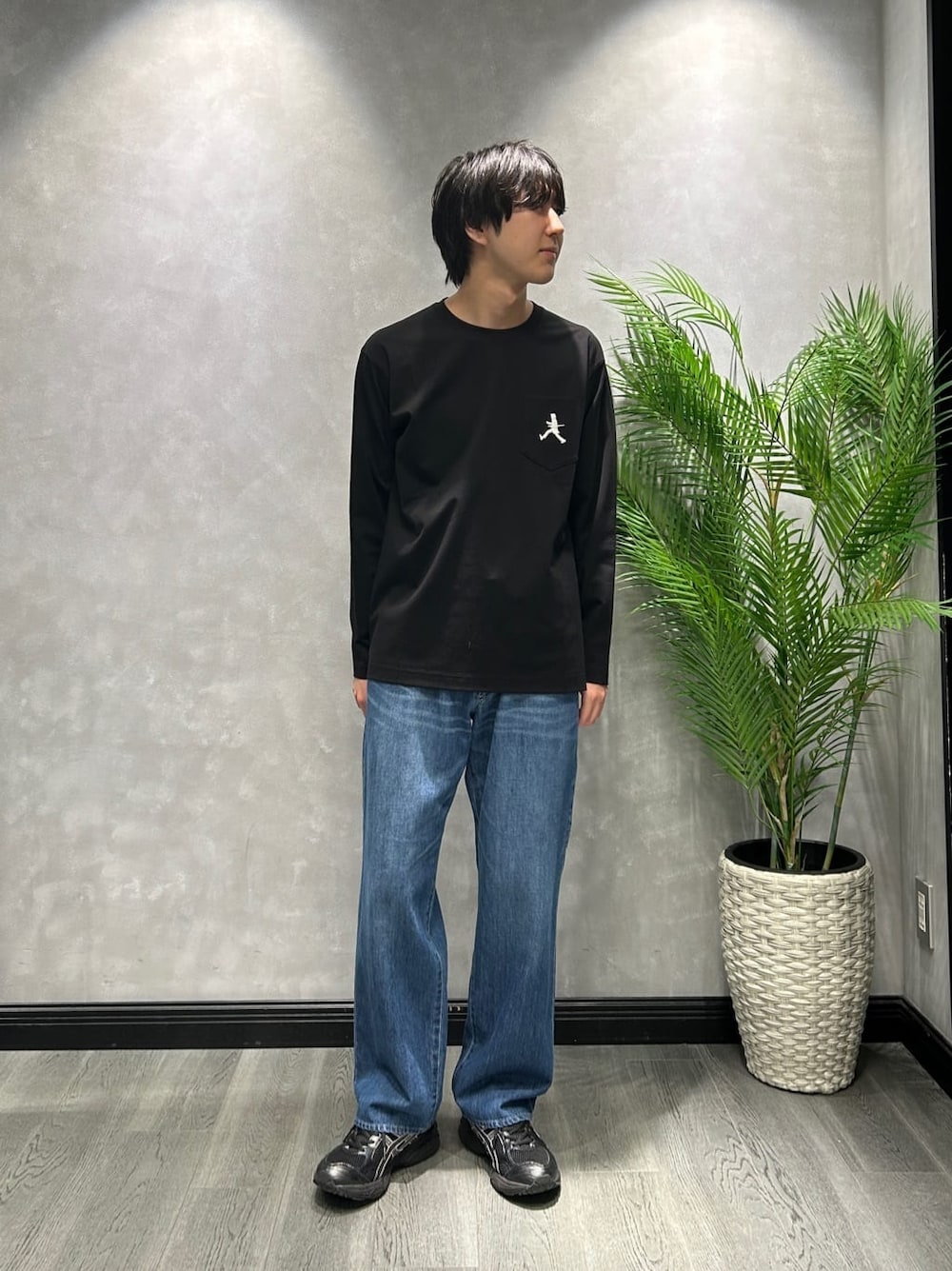 ブラック系のブルゾン、ブラック系のTシャツ/カットソー、ブルー系のデニムパンツを着用したメンズの春コーディネートの5枚目の写真