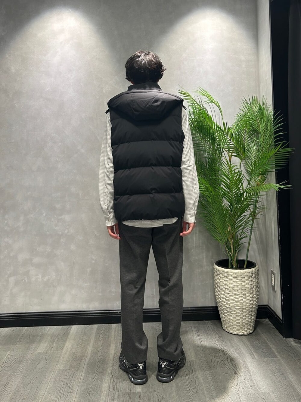 グレー系のシャツ/ブラウス、ブラック系のスラックス、ベージュ系のトートバッグを着用したメンズの冬コーディネートの6枚目の写真