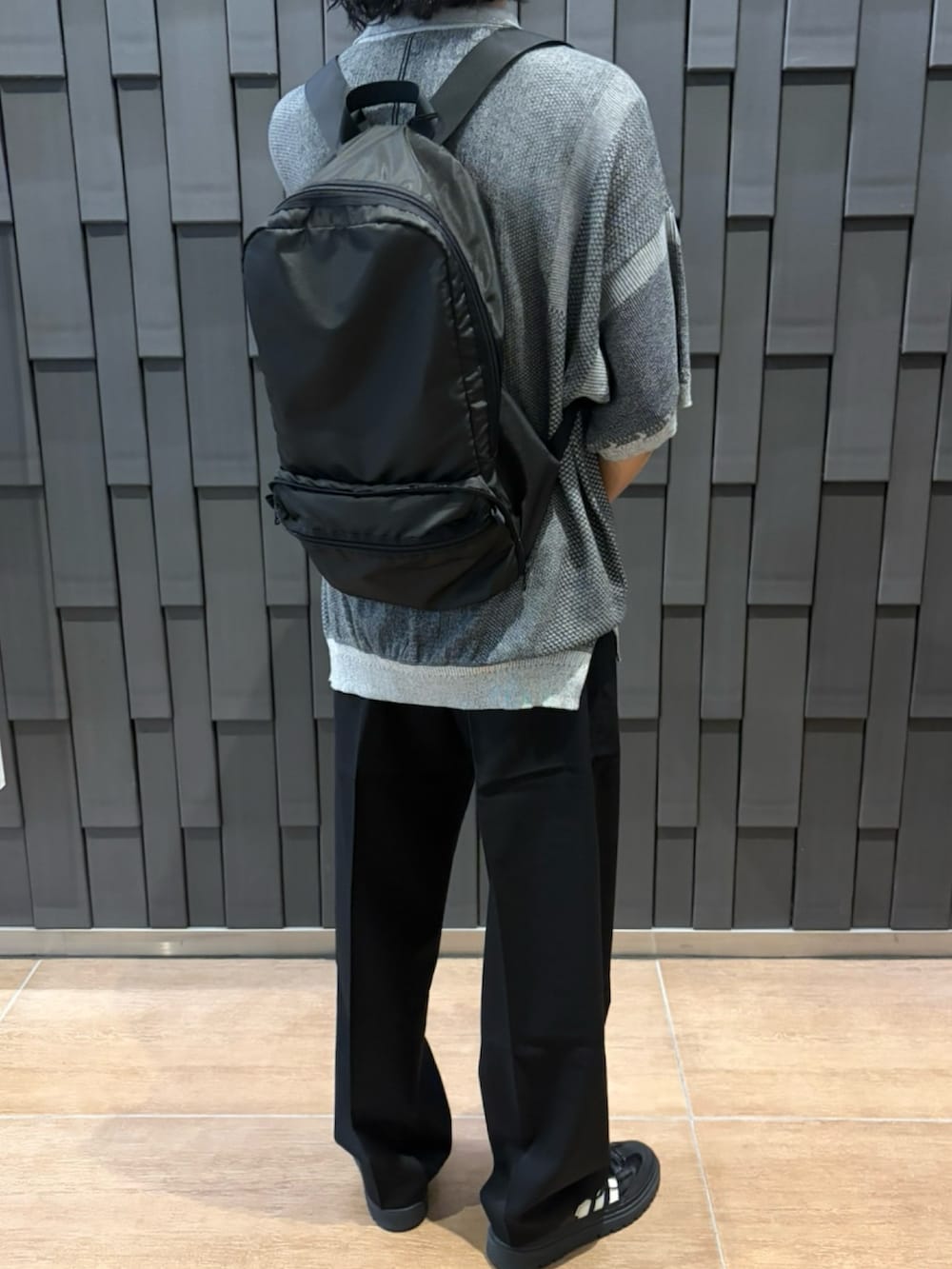 ブラック系のバックパック/リュック、ブラック系のスラックスを着用したメンズの夏コーディネートの2枚目の写真
