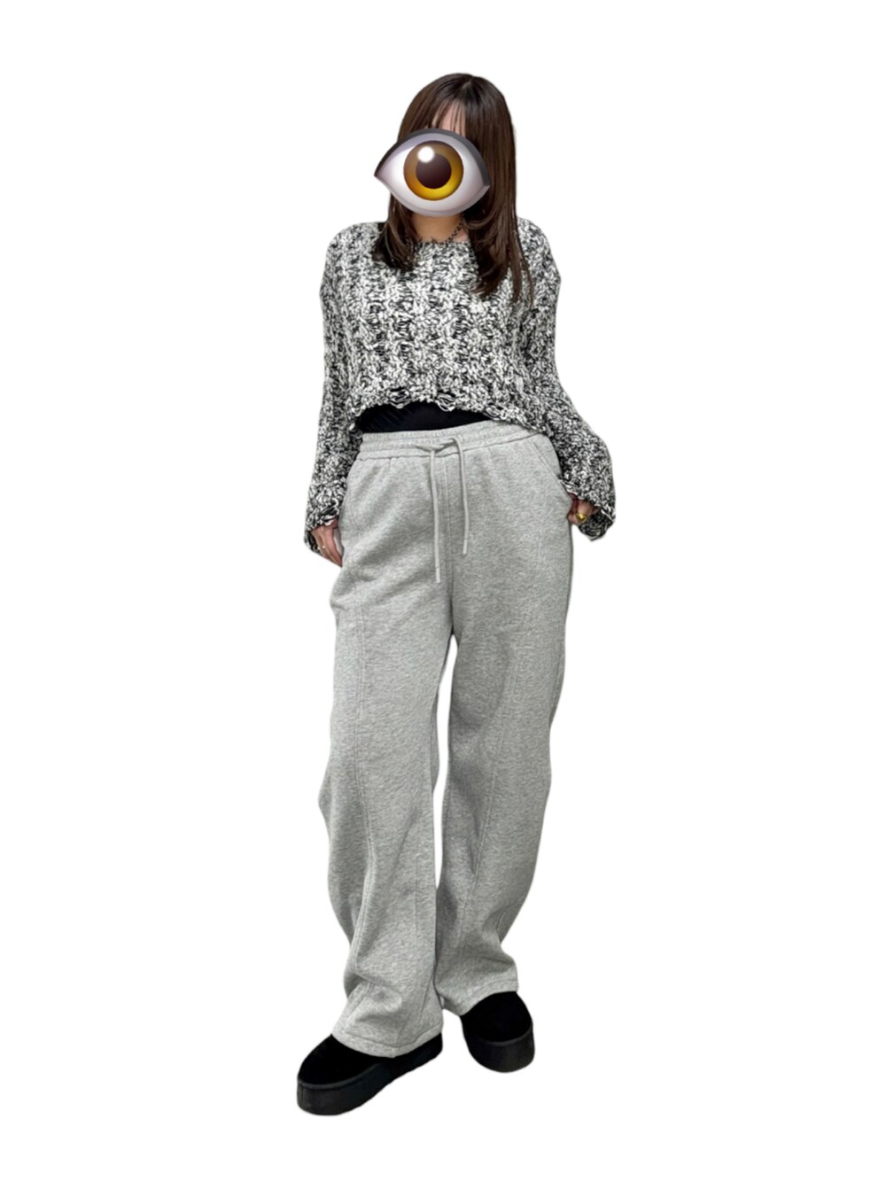 ブラック系のニット/セーター、ブラック系のブーツ、グレー系のスウェットパンツを着用したレディースの冬コーディネートの2枚目の写真