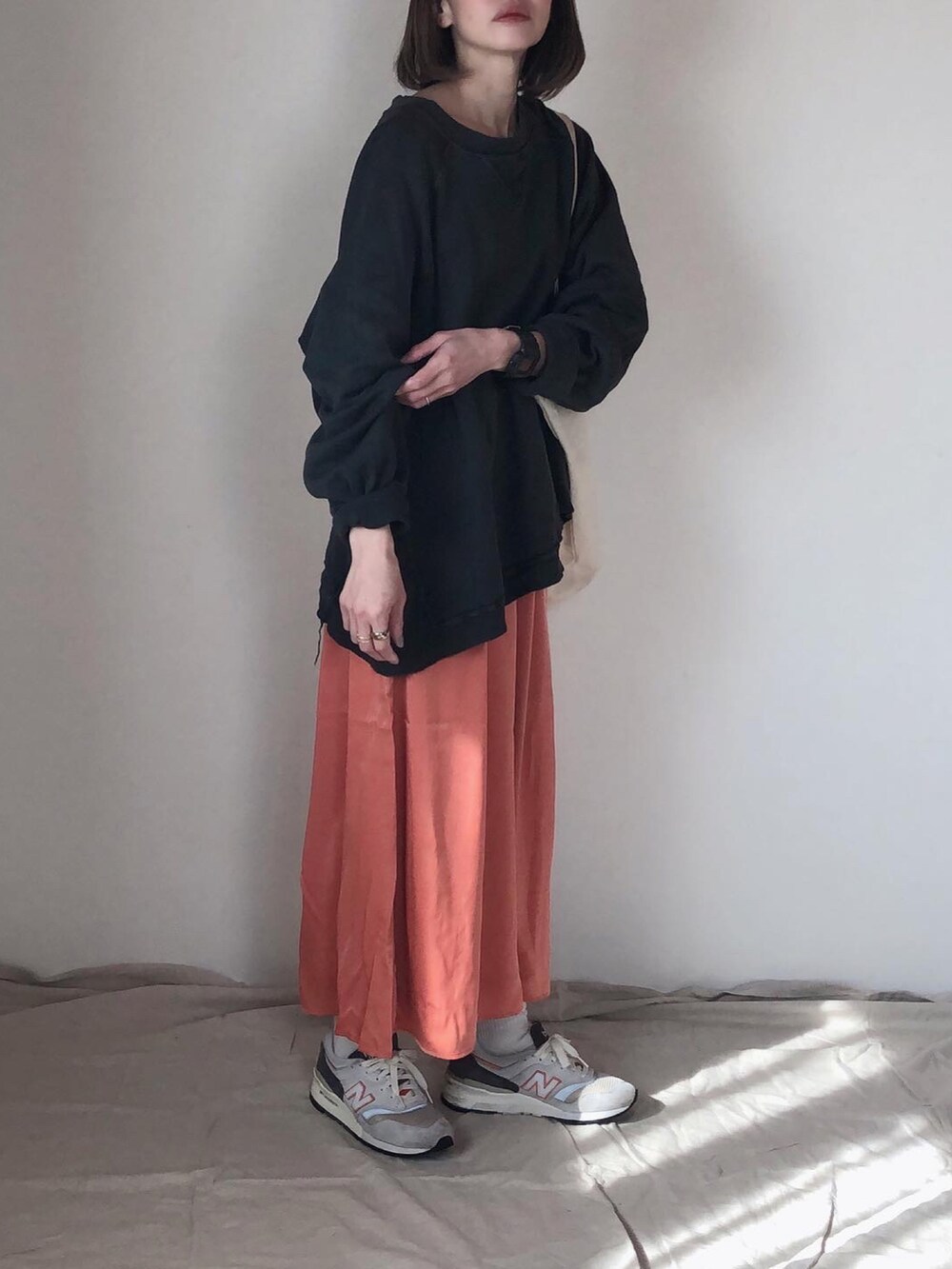 オレンジ系のその他パンツ、ブラック系のスウェット、グレー系のスニーカーを着用したレディースの春コーディネートの2枚目の写真