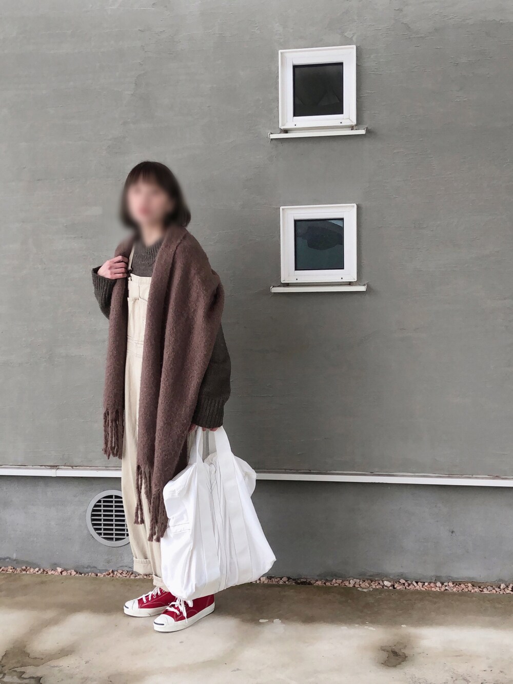 ブラウン系のニット/セーター、ベージュ系のサロペット/オーバーオール、ホワイト系のトートバッグを着用したレディースの冬コーディネートの5枚目の写真