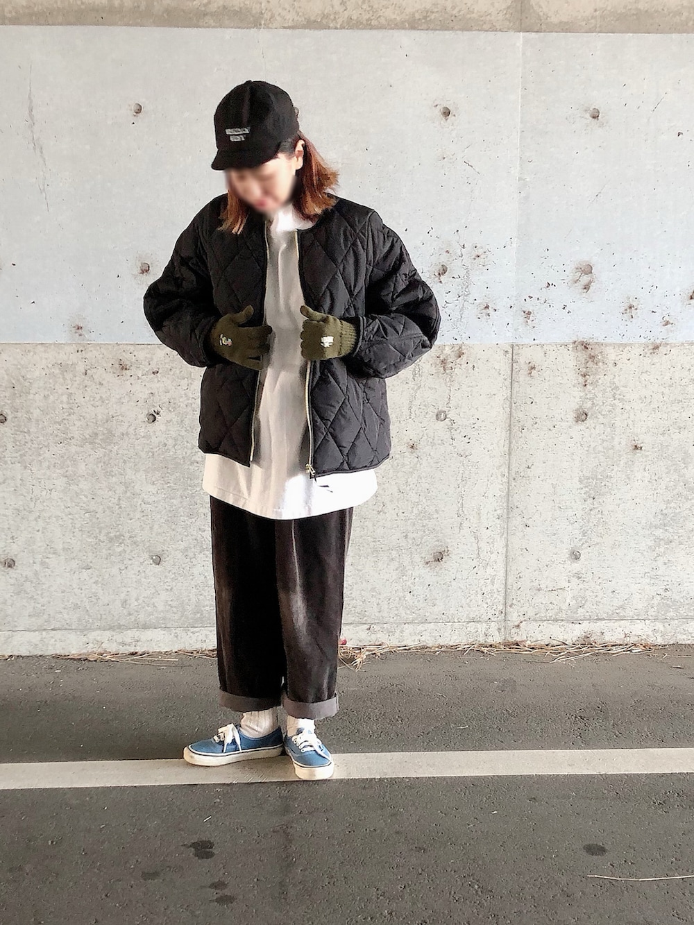 ブラック系のその他アウター、ブルー系のスニーカー、ブラック系のキャップを着用したレディースの冬コーディネートの2枚目の写真