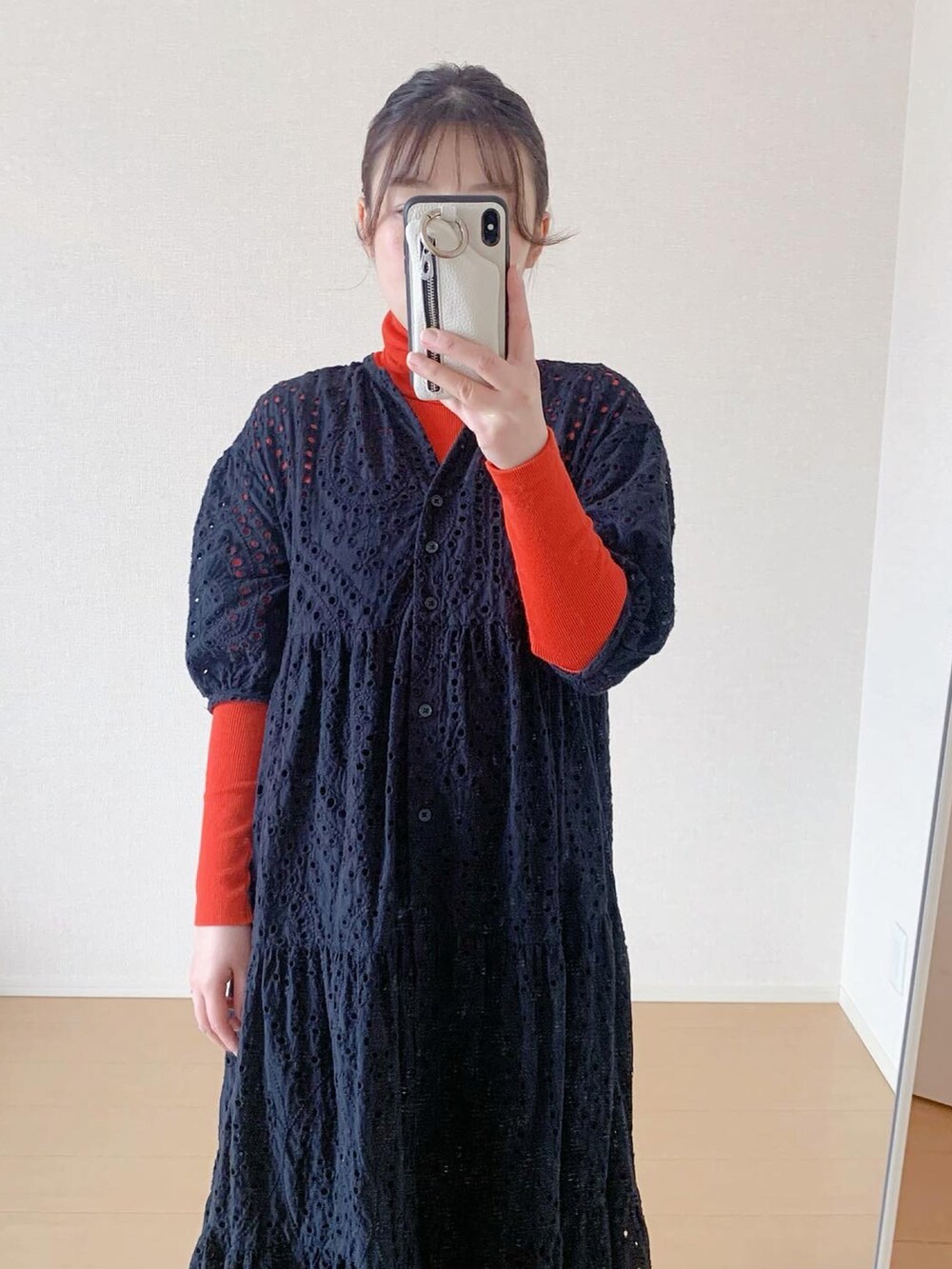オレンジ系のTシャツ/カットソー、ブラック系のワンピース、ブラック系のスニーカーを着用したレディースの春コーディネートの2枚目の写真