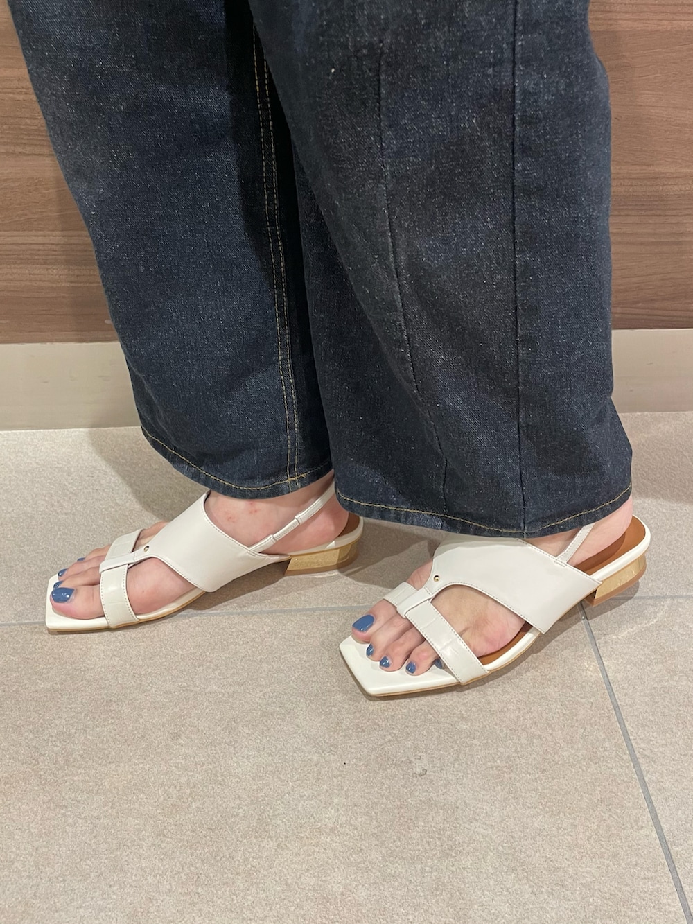 ブルー系のシャツ/ブラウス、ブラック系のトートバッグ、ホワイト系のサンダルを着用したレディースの夏コーディネートの2枚目の写真