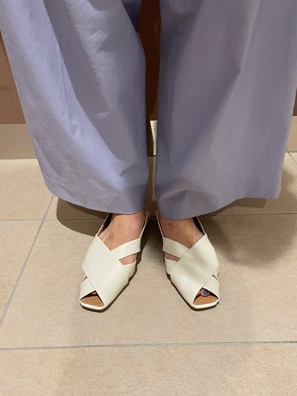 ブルー系のその他パンツ、ホワイト系のサンダル、ホワイト系のトートバッグを着用したレディースの夏コーディネートの2枚目の写真