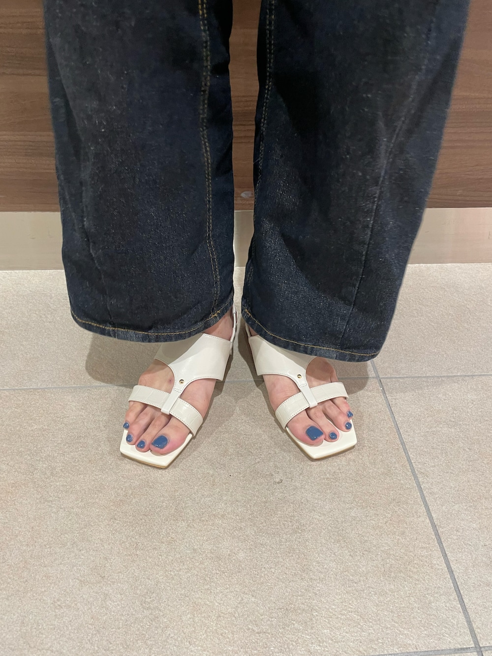 ブルー系のシャツ/ブラウス、ブラック系のトートバッグ、ホワイト系のサンダルを着用したレディースの夏コーディネートの3枚目の写真