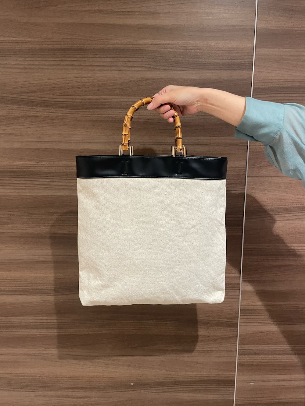 ブルー系のシャツ/ブラウス、ブラック系のトートバッグ、ホワイト系のサンダルを着用したレディースの夏コーディネートの5枚目の写真