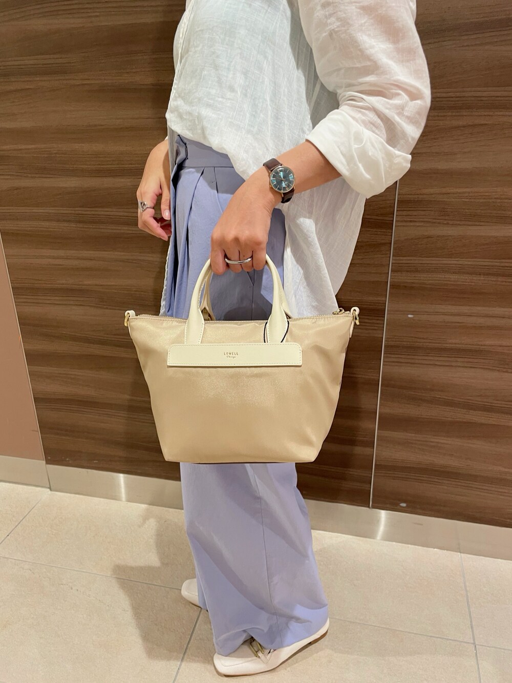 ベージュ系のショルダーバッグ、ブルー系のその他パンツ、ホワイト系のローファーを着用したレディースの夏コーディネートの4枚目の写真