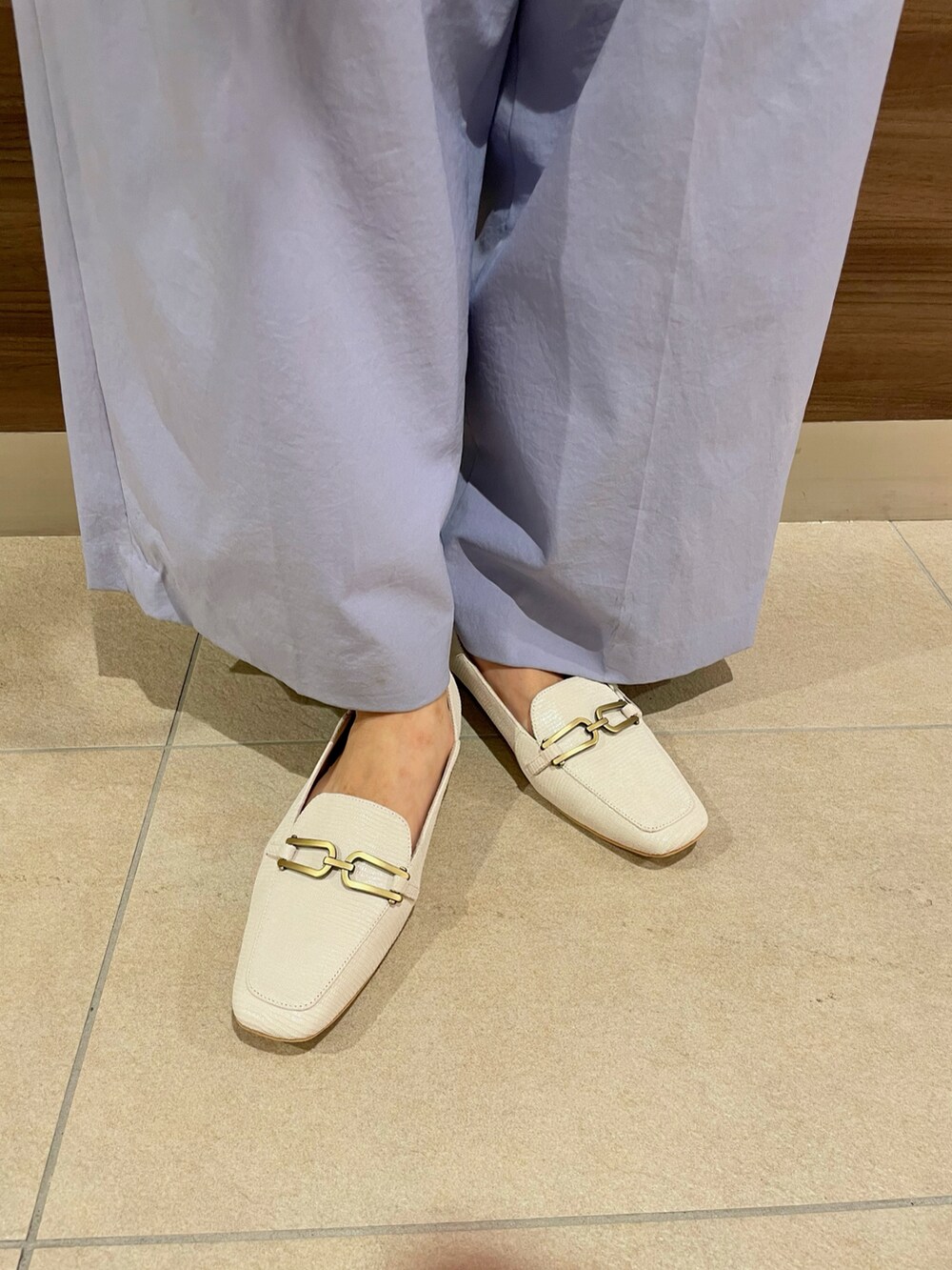 ベージュ系のショルダーバッグ、ブルー系のその他パンツ、ホワイト系のローファーを着用したレディースの夏コーディネートの2枚目の写真