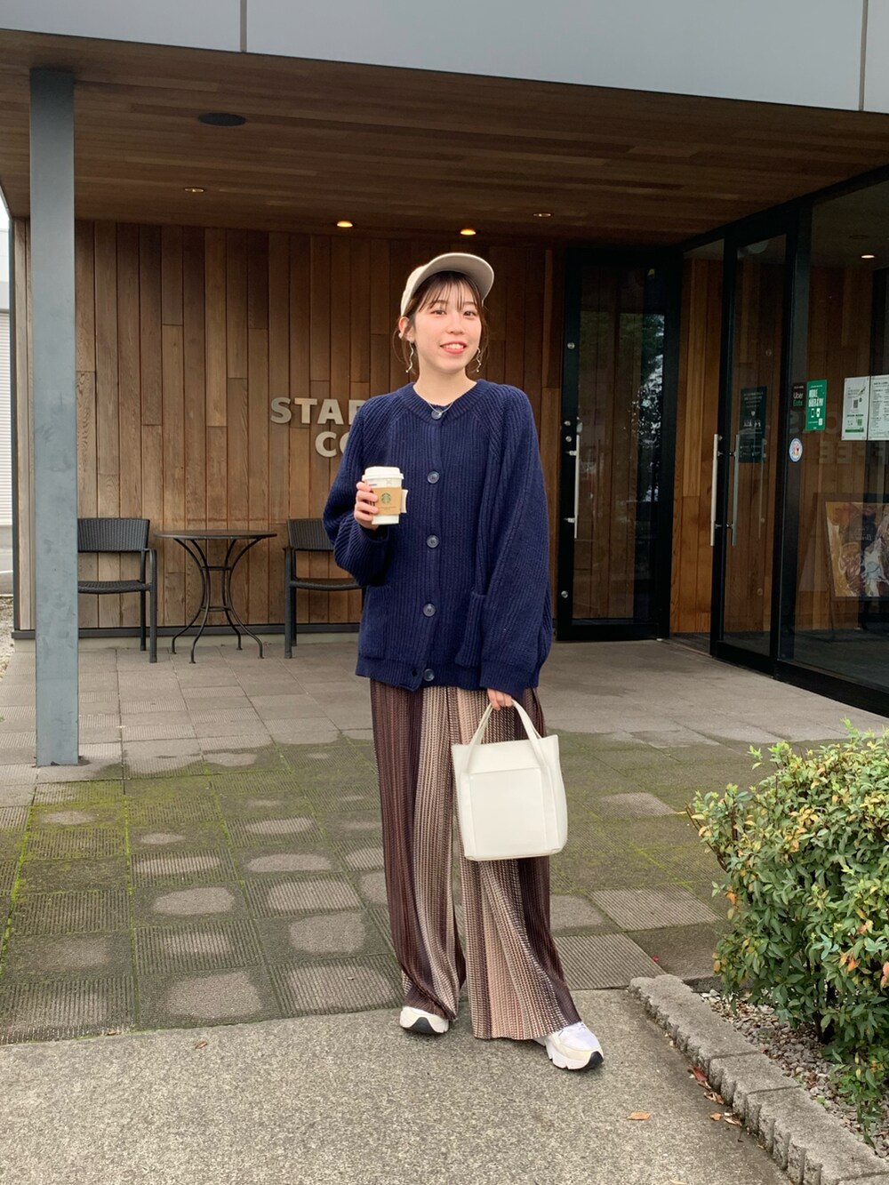 ブルー系のカーディガン/ボレロ、ブラウン系のその他パンツ、ホワイト系のショルダーバッグを着用したレディースの秋コーディネートの2枚目の写真