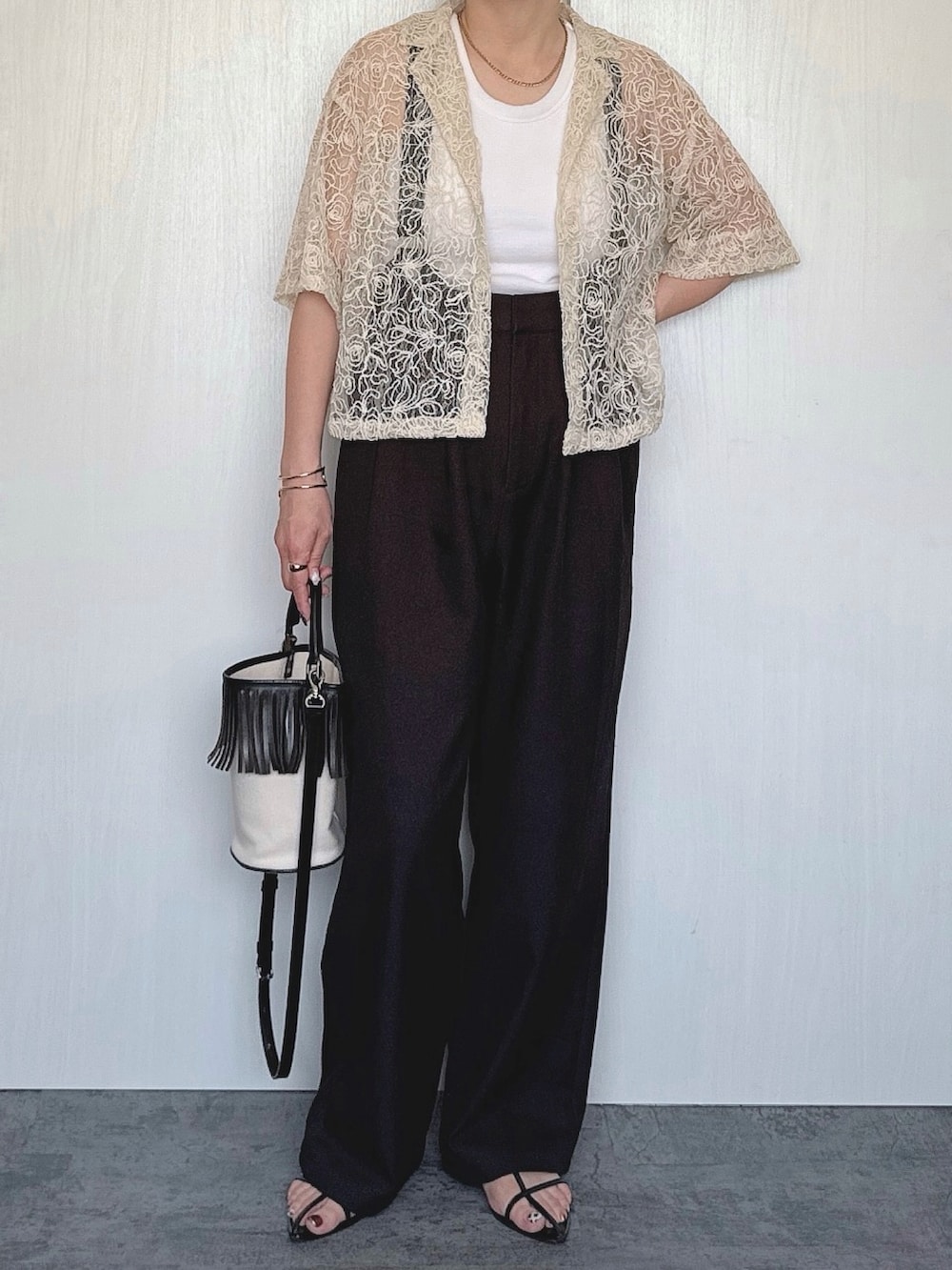 ホワイト系のシャツ/ブラウス、ブラック系のパンツを着用したレディースの夏コーディネートの2枚目の写真