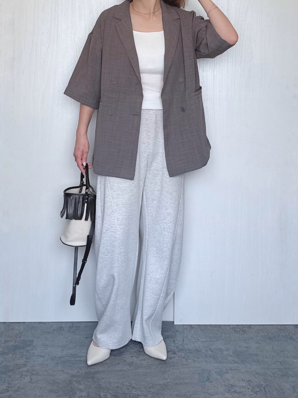 グレー系のその他パンツ、ホワイト系のタンクトップ、グレー系のテーラードジャケットを着用したレディースの春コーディネートの2枚目の写真