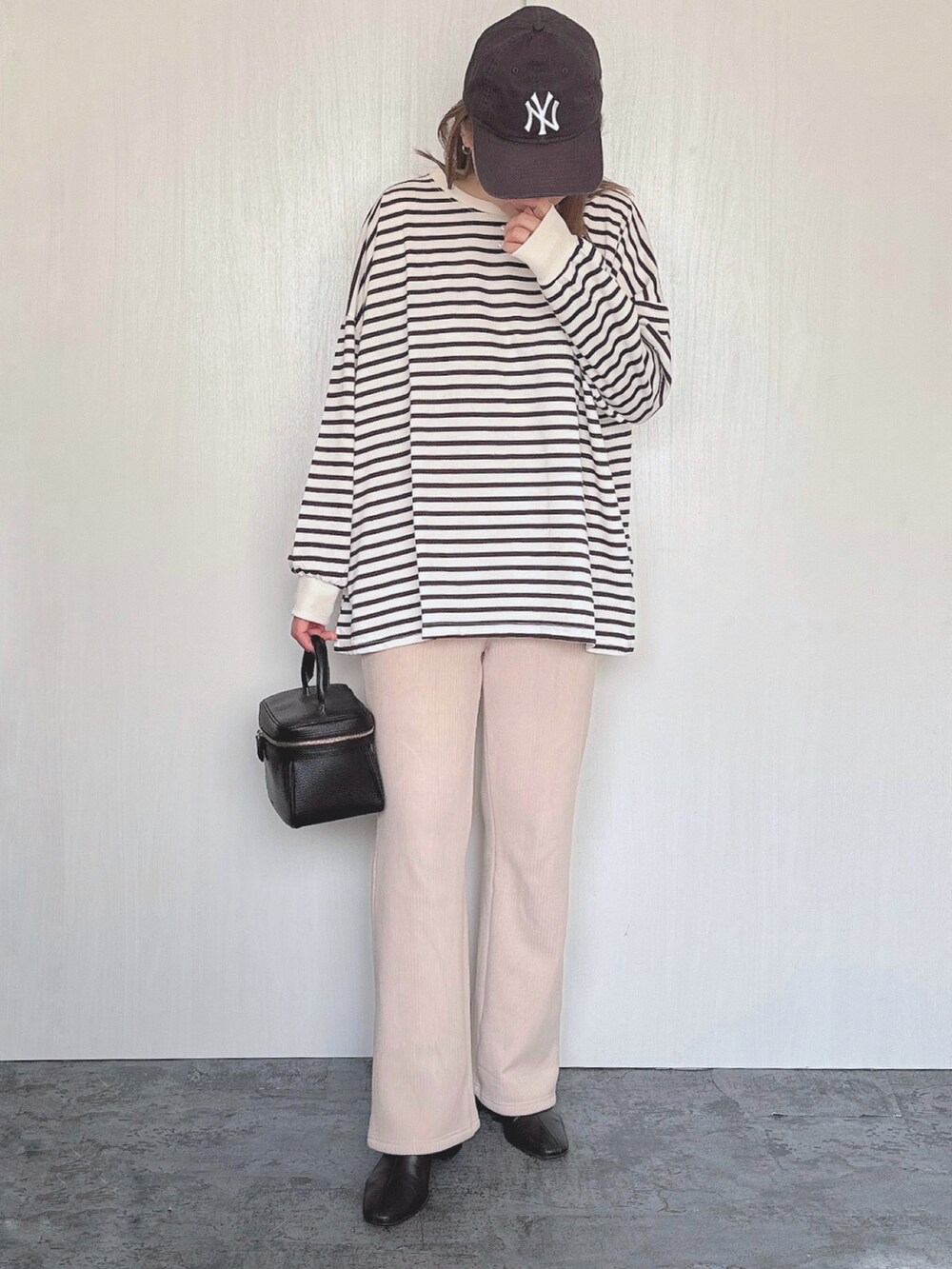 ホワイト系のスウェット、ベージュ系のその他パンツ、ブラック系のバッグを着用したレディースの冬コーディネートの2枚目の写真