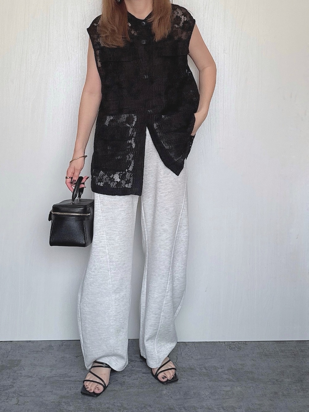 ブラック系のベスト、グレー系のその他パンツ、ブラック系のバッグを着用したレディースの夏コーディネートの2枚目の写真