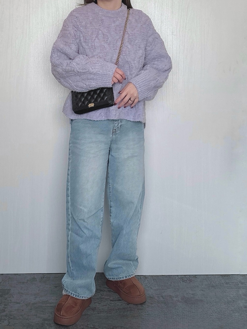 ブラック系のバッグ、パープル系のニット/セーター、ブルー系のデニムパンツを着用したレディースの冬コーディネートの2枚目の写真