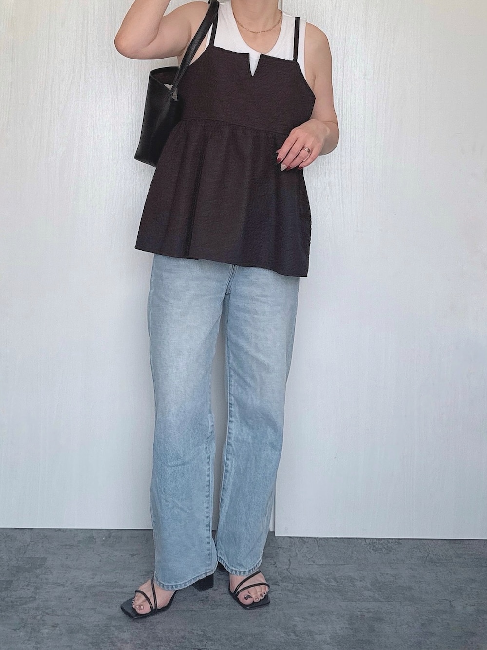 ブラック系のキャミソール、ブルー系のデニムパンツを着用したレディースの夏コーディネートの2枚目の写真