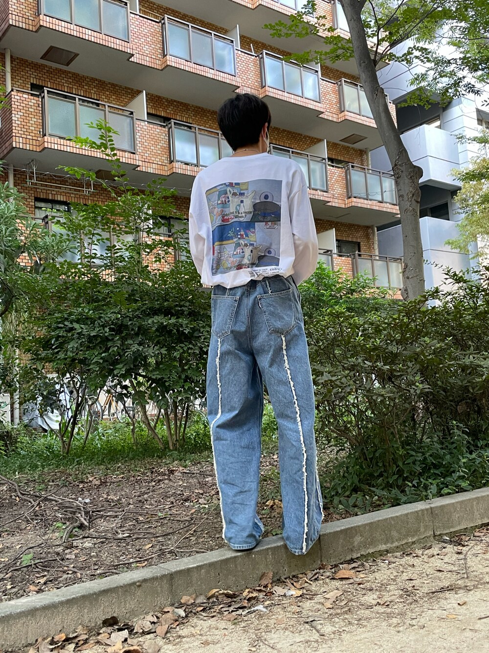 ホワイト系のTシャツ/カットソー、ブルー系のデニムパンツ、グリーン系のスニーカーを着用したメンズの秋コーディネートの2枚目の写真