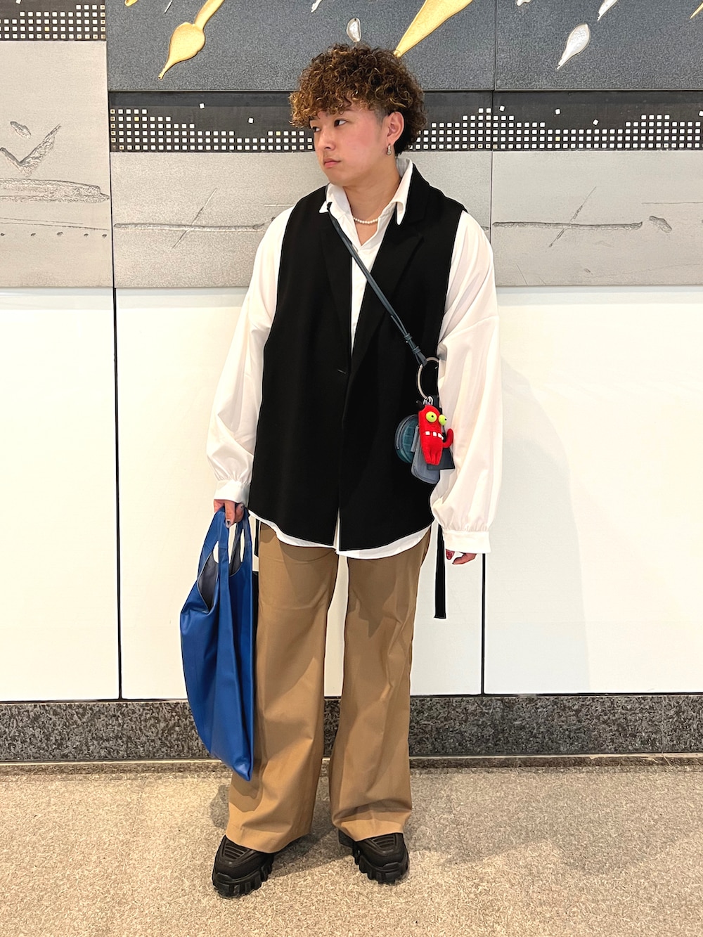 ブラック系のジャケット/アウター、ホワイト系のシャツ/ブラウス、ベージュ系のパンツを着用したメンズの春コーディネートの2枚目の写真