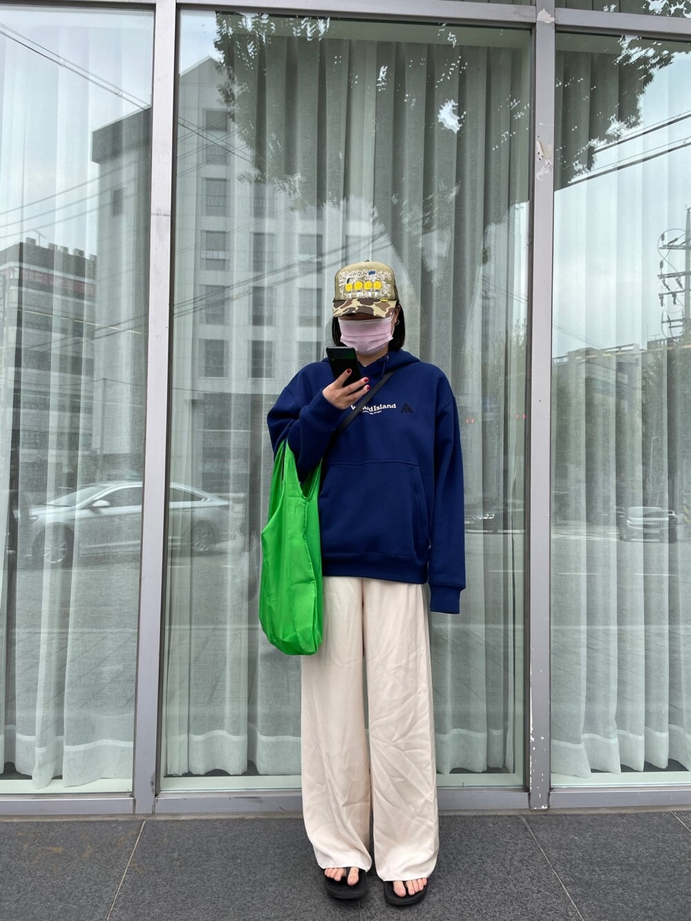 グリーン系のバッグ、ブルー系のトップスを着用したレディースの秋コーディネートの2枚目の写真