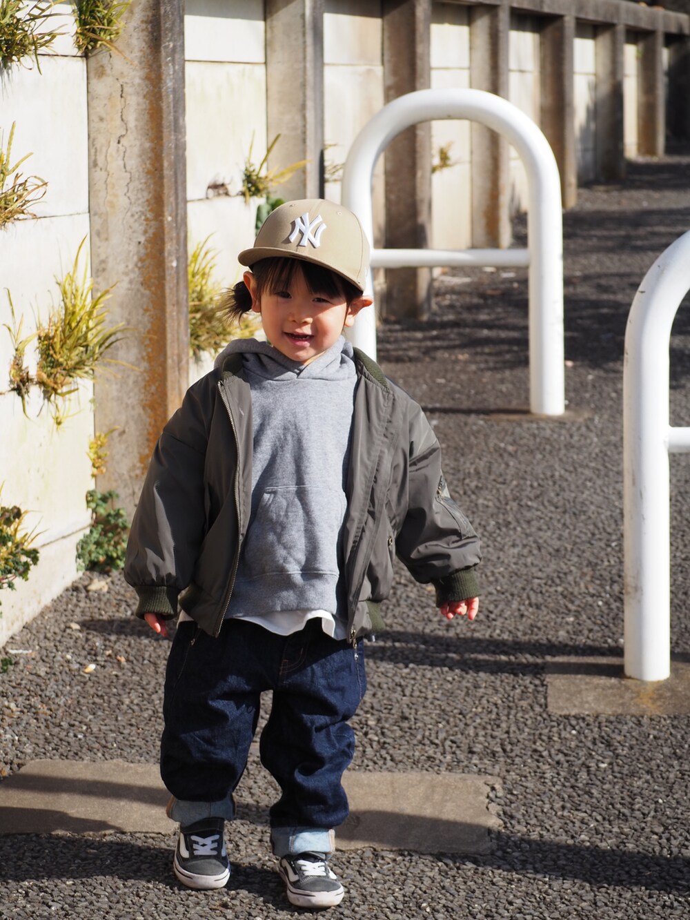 グリーン系のMA-1、ブルー系のデニムパンツ、ブラック系のスニーカーを着用したキッズの冬コーディネートの2枚目の写真