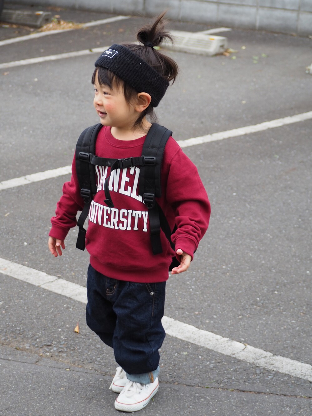 レッド系のスウェット、ブルー系のデニムパンツ、ホワイト系のスニーカーを着用したキッズの春コーディネートの2枚目の写真