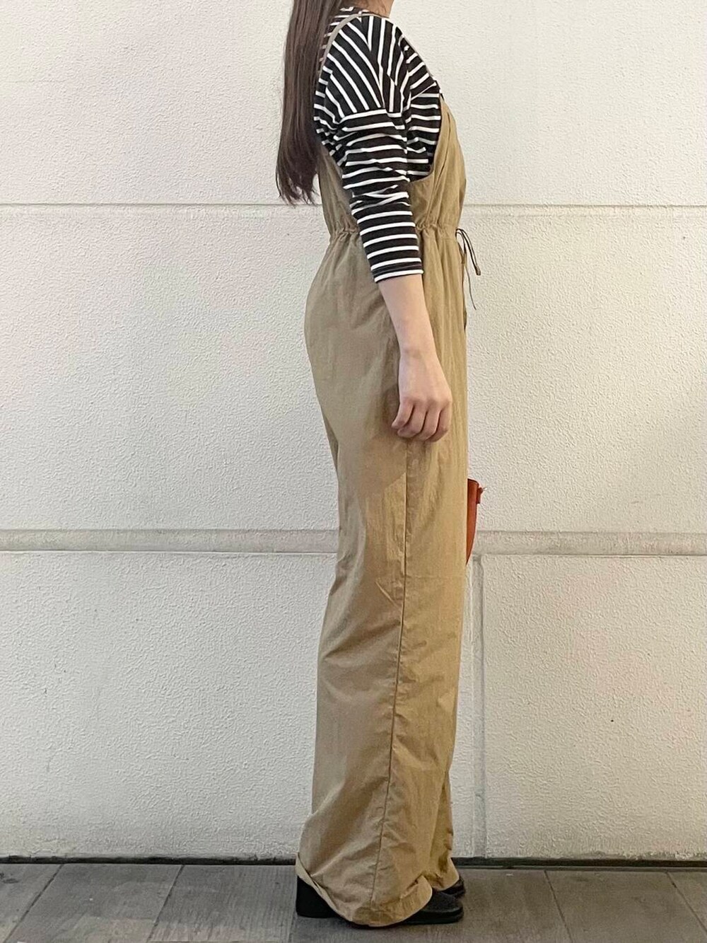 ベージュ系のサロペット/オーバーオール、ブラウン系のTシャツ/カットソーを着用したレディースの秋コーディネートの4枚目の写真