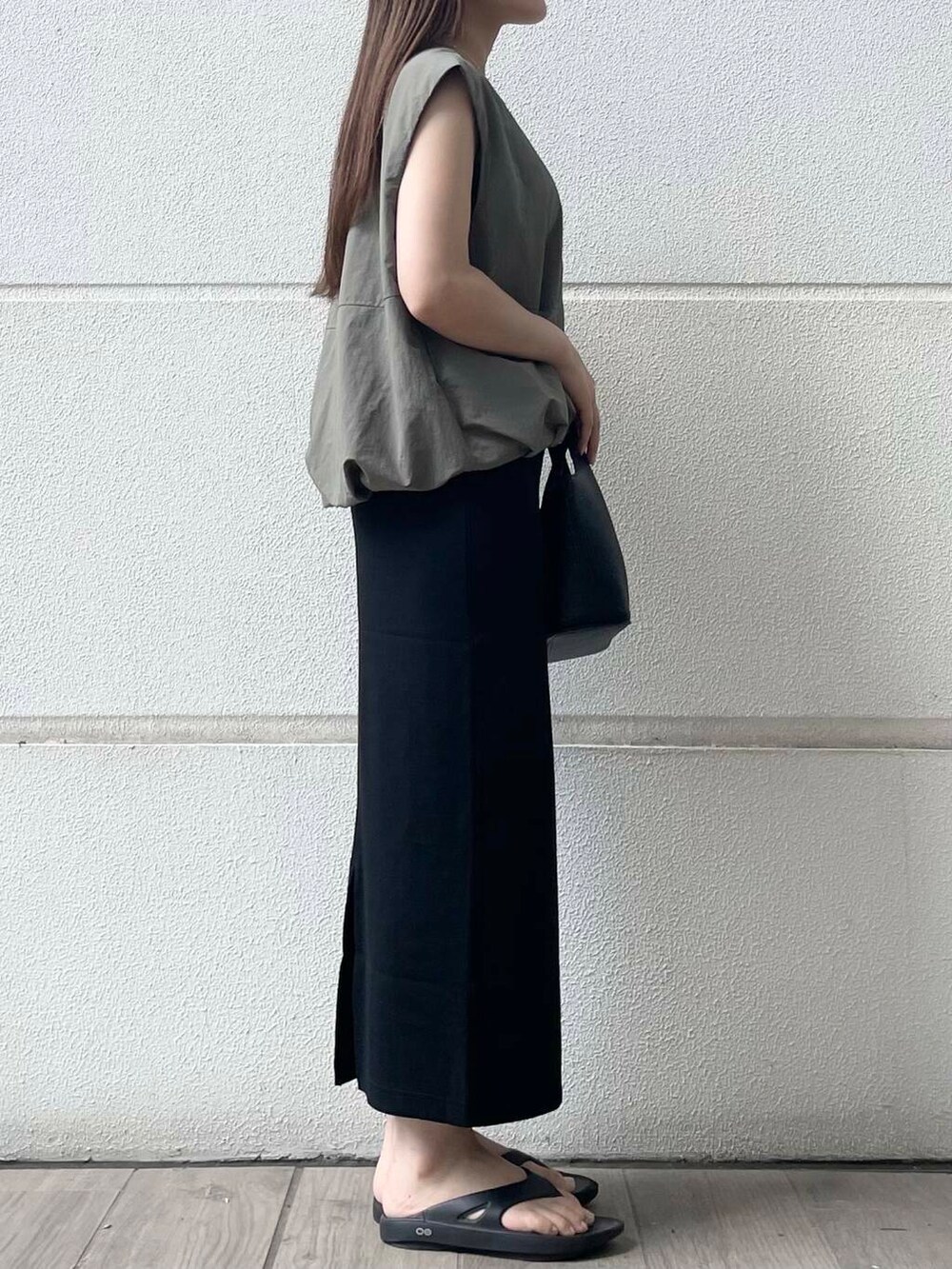 ブラック系のスカート、グリーン系のベストを着用したレディースの夏コーディネートの3枚目の写真