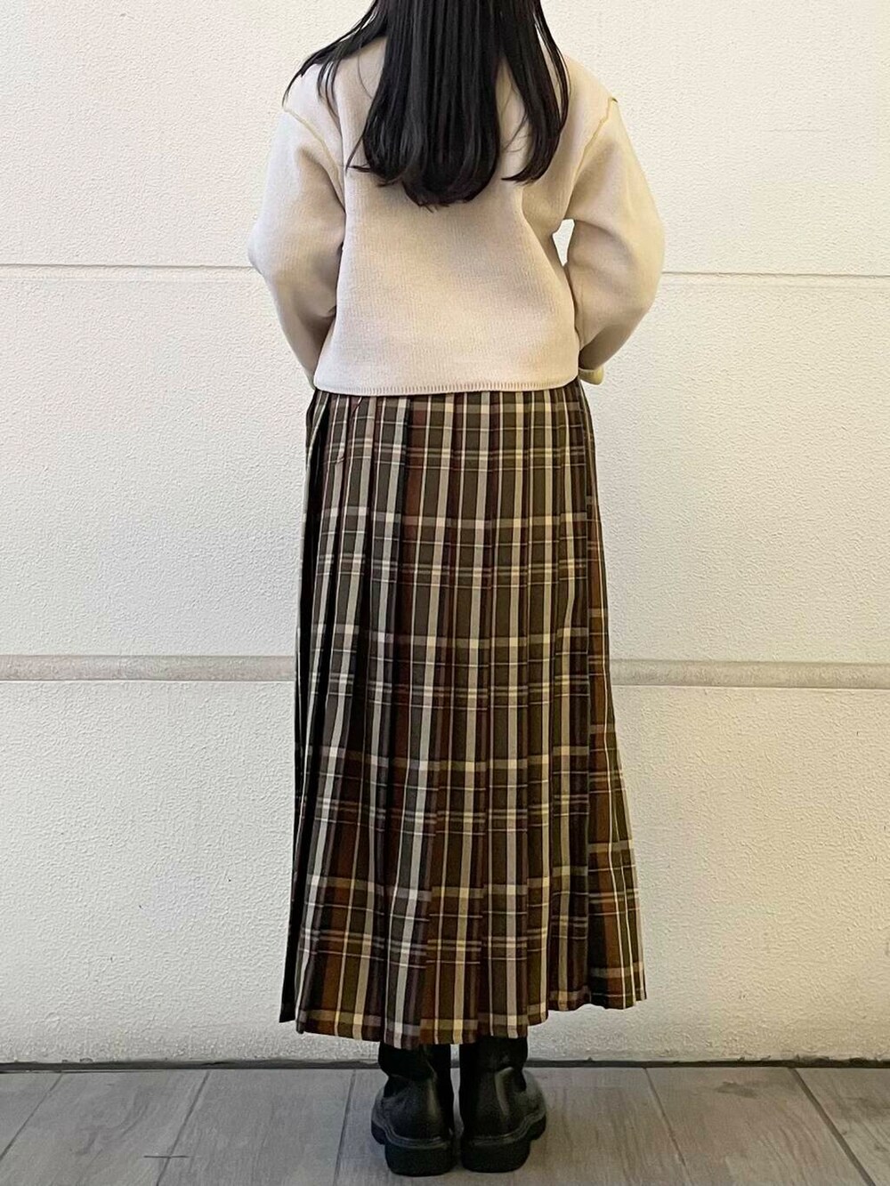 グリーン系のスカート、ホワイト系のニット/セーターを着用したレディースの冬コーディネートの3枚目の写真