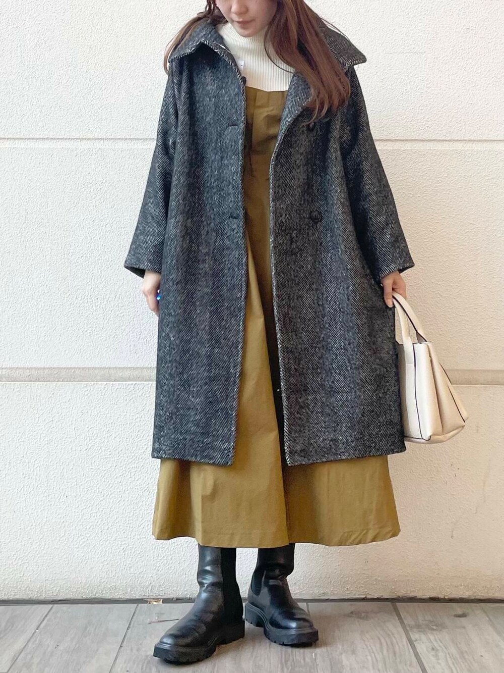 イエロー系のワンピース、ブラック系のその他アウターを着用したレディースの冬コーディネートの5枚目の写真