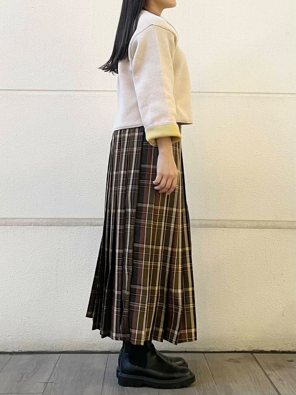 グリーン系のスカート、ホワイト系のニット/セーターを着用したレディースの冬コーディネートの4枚目の写真