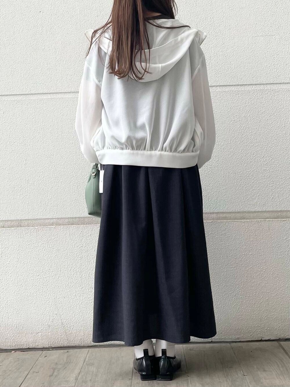 ホワイト系のマウンテンパーカー、グレー系のワンピースを着用したレディースの春コーディネートの3枚目の写真