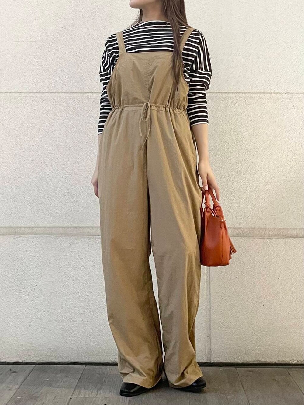 ベージュ系のサロペット/オーバーオール、ブラウン系のTシャツ/カットソーを着用したレディースの秋コーディネートの2枚目の写真