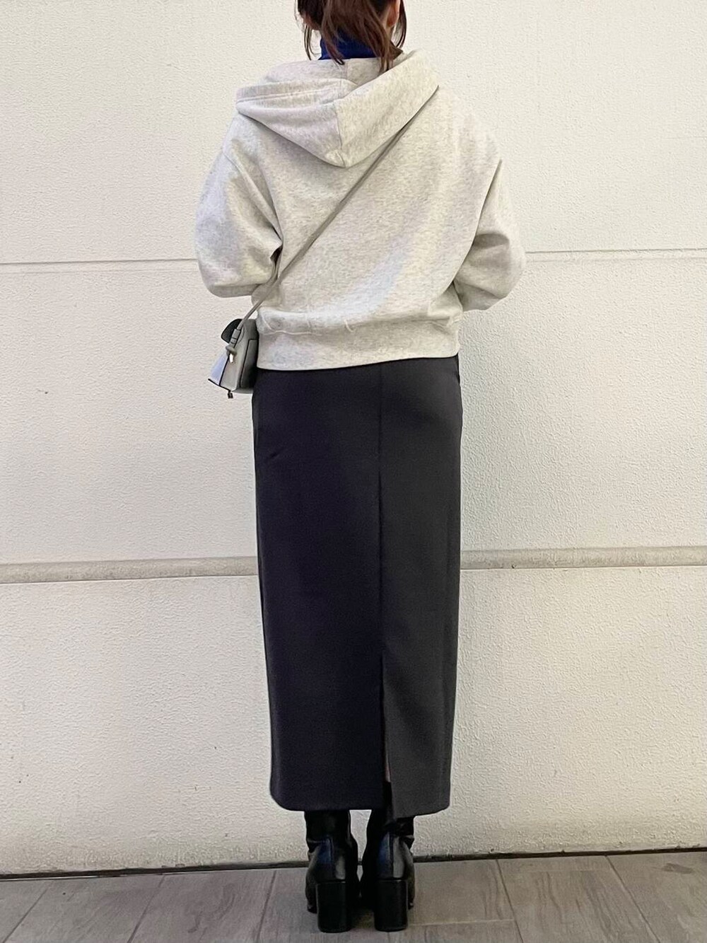 ブルー系のニット/セーター、ホワイト系のパーカー、グレー系のスカートを着用したレディースの冬コーディネートの3枚目の写真