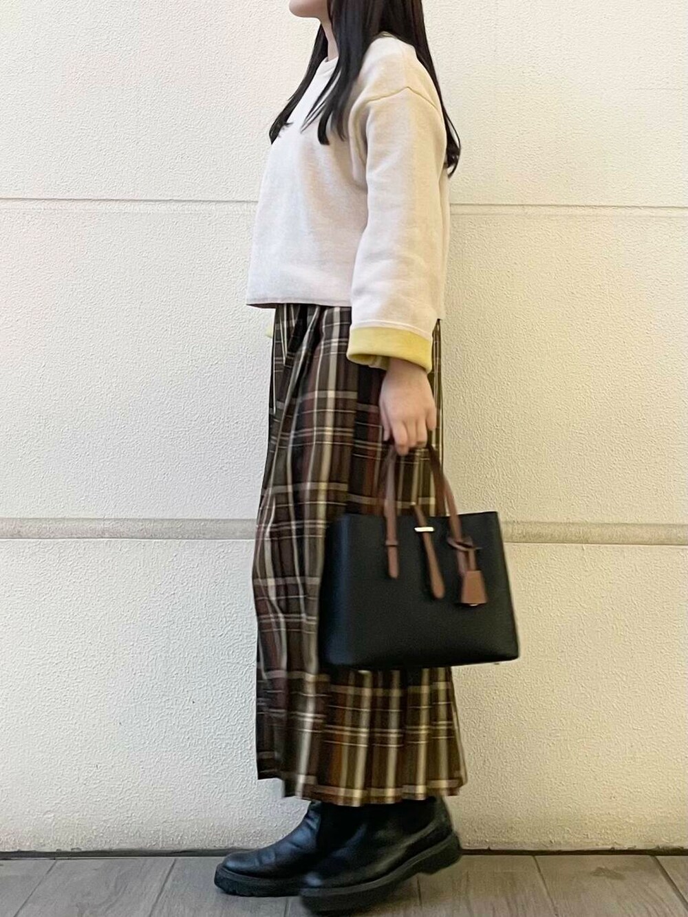 グリーン系のスカート、ホワイト系のニット/セーターを着用したレディースの冬コーディネートの2枚目の写真