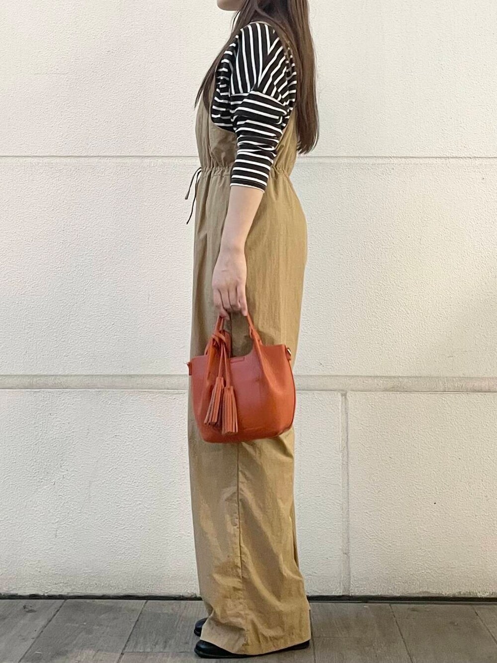 ベージュ系のサロペット/オーバーオール、ブラウン系のTシャツ/カットソーを着用したレディースの秋コーディネートの3枚目の写真