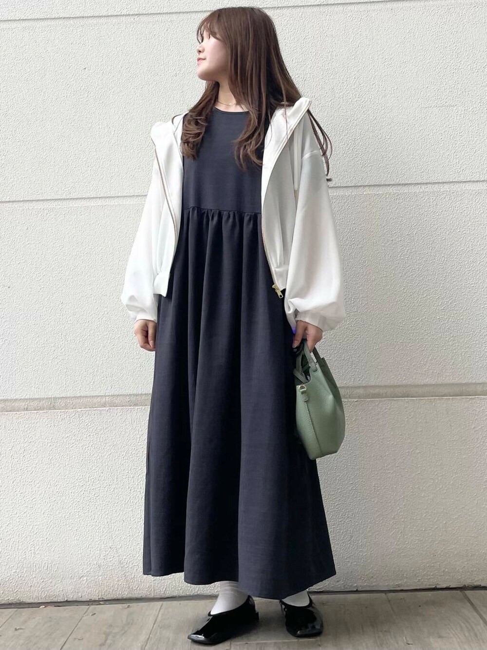 ホワイト系のマウンテンパーカー、グレー系のワンピースを着用したレディースの春コーディネートの2枚目の写真