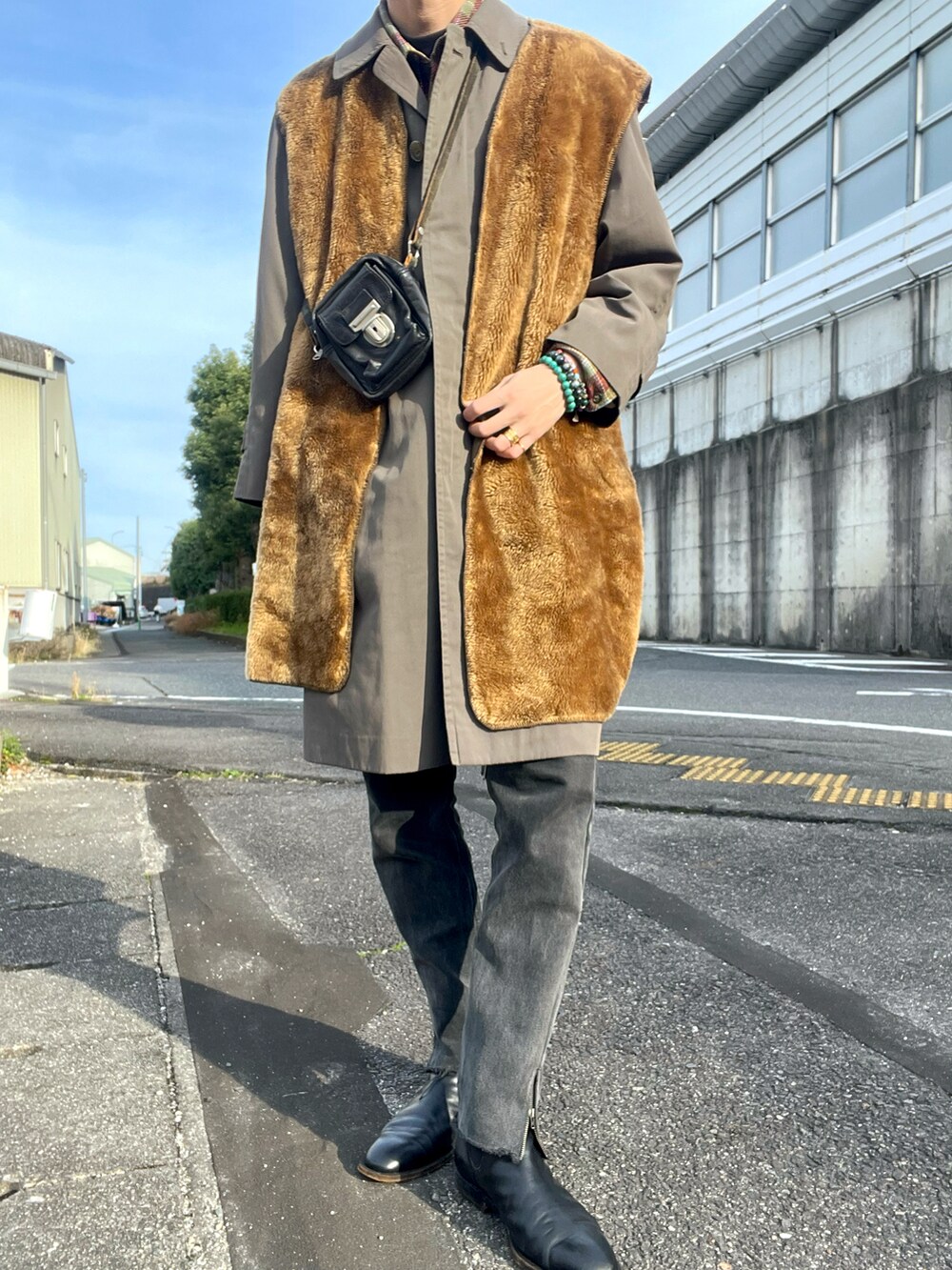 ブラウン系のミリタリージャケット、グレー系のステンカラーコート、ブラック系のショルダーバッグを着用したメンズの冬コーディネートの2枚目の写真