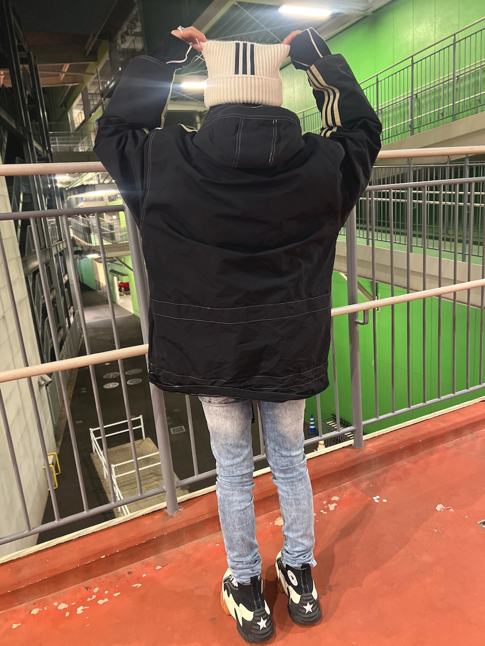 ブラック系のスニーカー、ブラック系のナイロンジャケット、ブラック系のトップスを着用したメンズの冬コーディネートの3枚目の写真