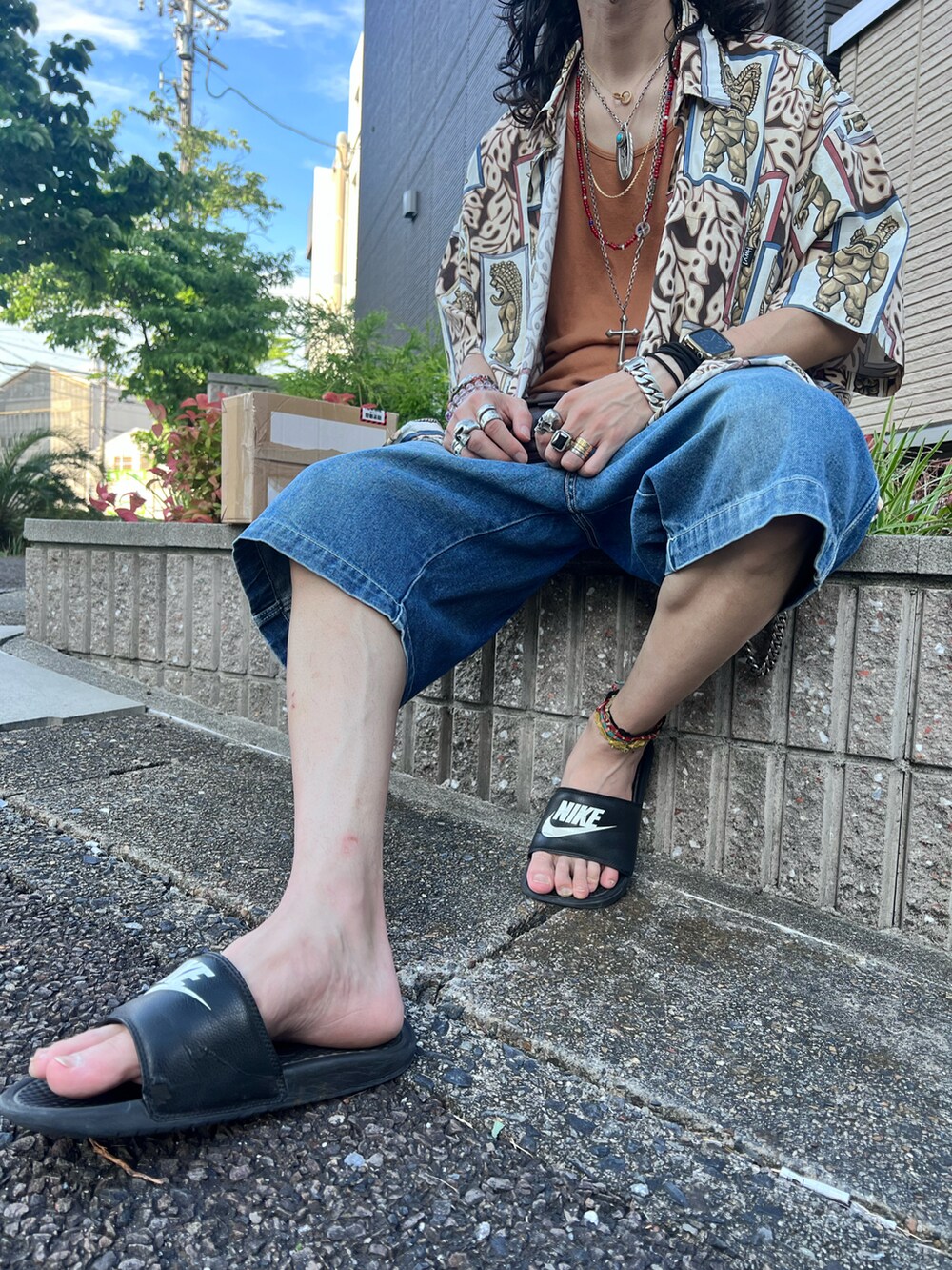 ブルー系のデニムパンツ、ブラック系のサンダル、ベージュ系のシャツ/ブラウスを着用したメンズの夏コーディネートの2枚目の写真