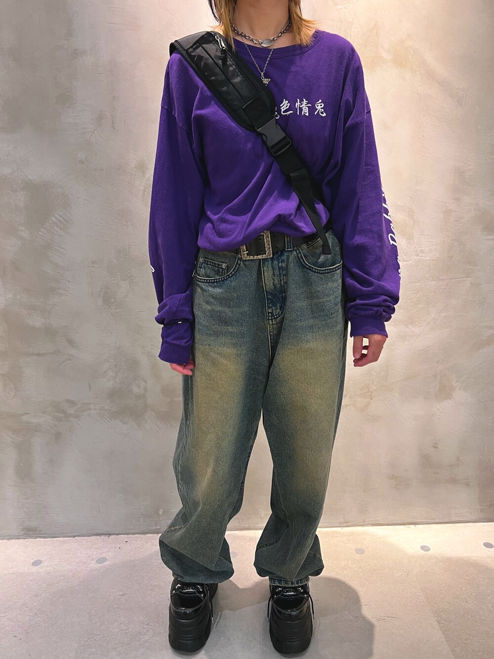 ブラック系のショルダーバッグ、パープル系のTシャツ/カットソー、ブラック系のスニーカーを着用したメンズの春コーディネートの2枚目の写真