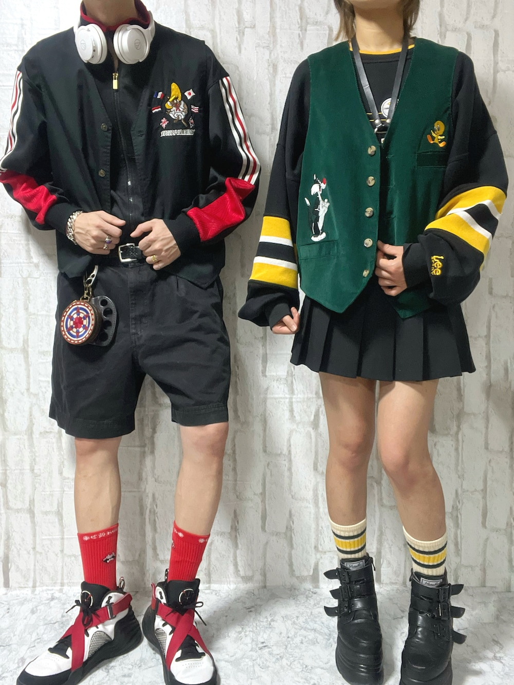 グリーン系のベスト、ブラック系のジャージ、レッド系のスニーカーを着用したメンズの春コーディネートの2枚目の写真