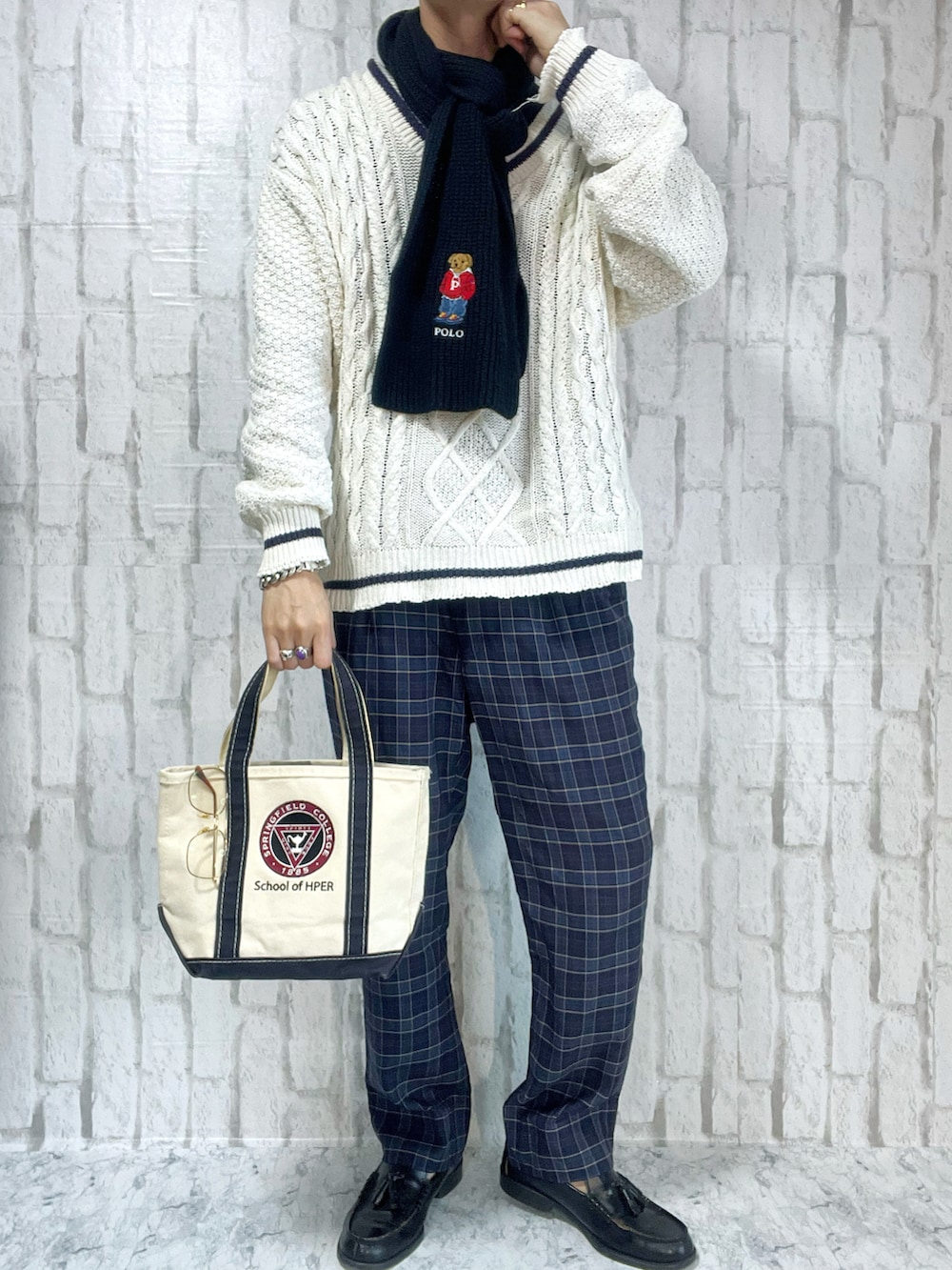 ホワイト系のニット/セーター、ブルー系のスラックス、ホワイト系のハンドバッグを着用したメンズの春コーディネートの2枚目の写真