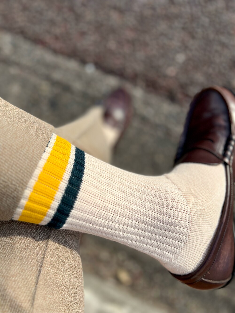 ベージュ系のニット/セーター、ブラウン系のショルダーバッグ、ベージュ系のスラックスを着用したメンズの冬コーディネートの2枚目の写真