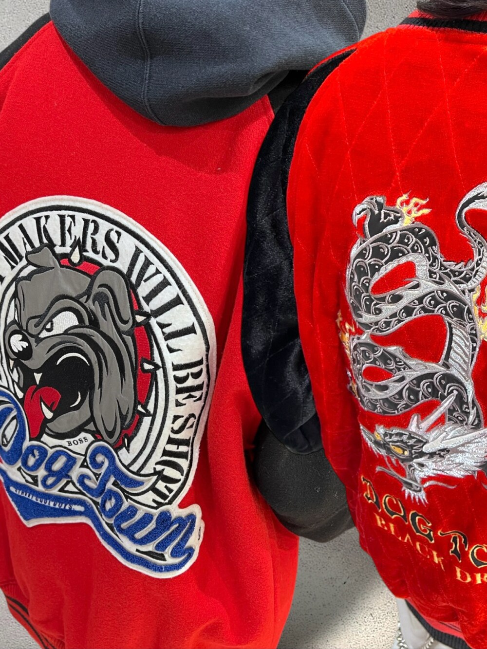 レッド系のスカジャン、ブラック系のニット/セーター、ベージュ系のチノパンツを着用したメンズの冬コーディネートの2枚目の写真