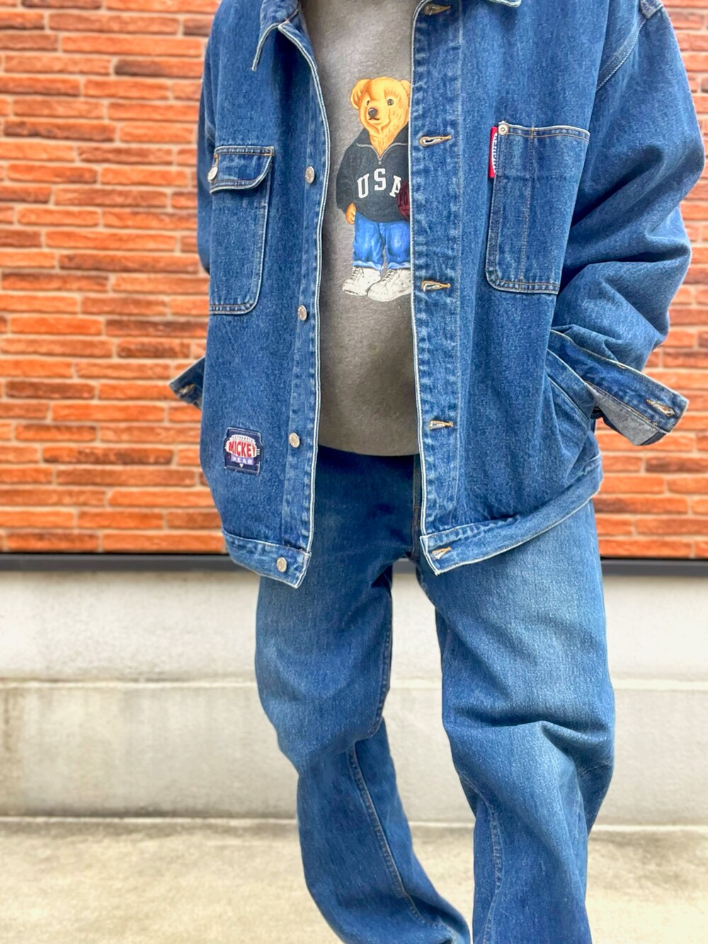 グレー系のスウェット、ブルー系のデニムジャケット、ホワイト系のパーカーを着用したメンズの春コーディネートの2枚目の写真