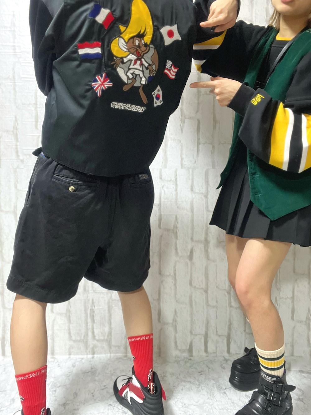 グリーン系のベスト、ブラック系のジャージ、レッド系のスニーカーを着用したメンズの春コーディネートの3枚目の写真