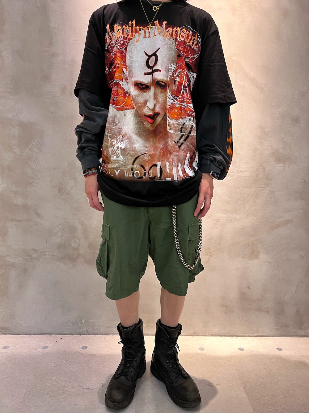 グリーン系のカーゴパンツ、ブラック系のブーツ、ブラック系のTシャツ/カットソーを着用したメンズの夏コーディネートの2枚目の写真