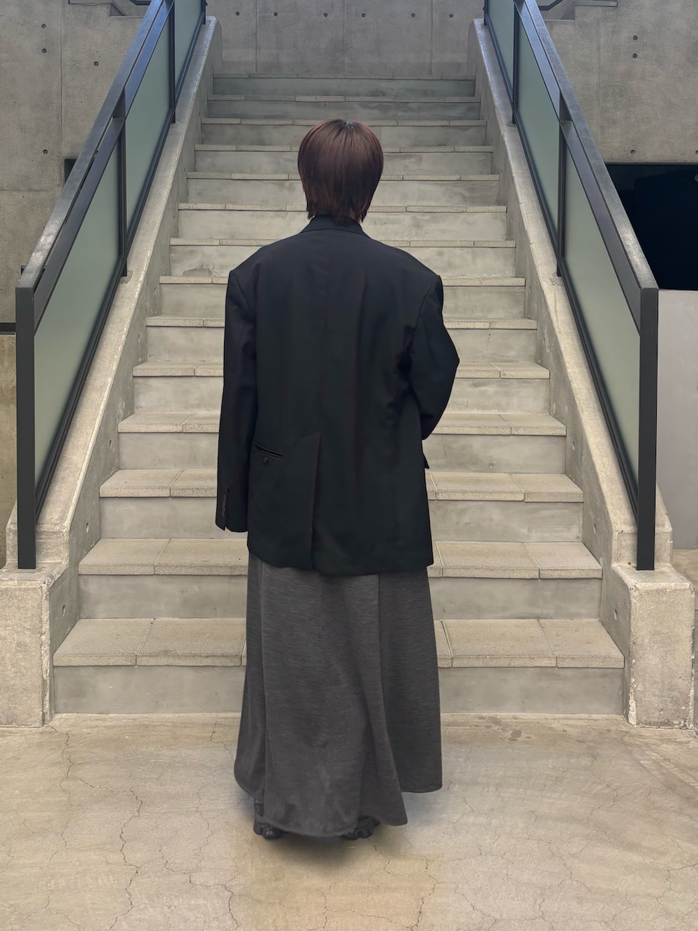 グレー系のワンピース、ブラック系のその他アウター、グレー系のスニーカーを着用したレディースの春コーディネートの2枚目の写真